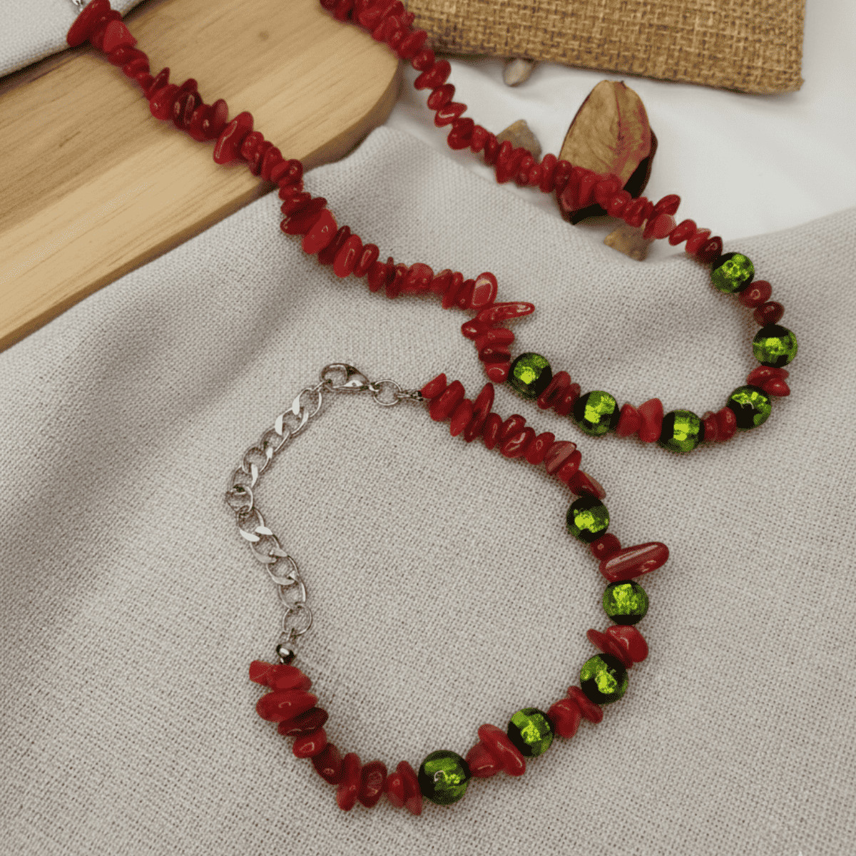 Necklace with red and green beads on a textured surface