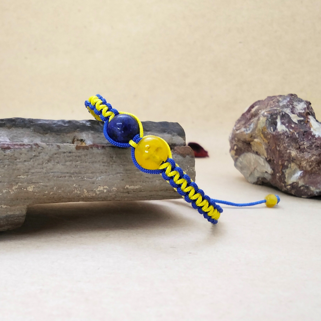 Bracelet with blue and yellow cord on a stone surface