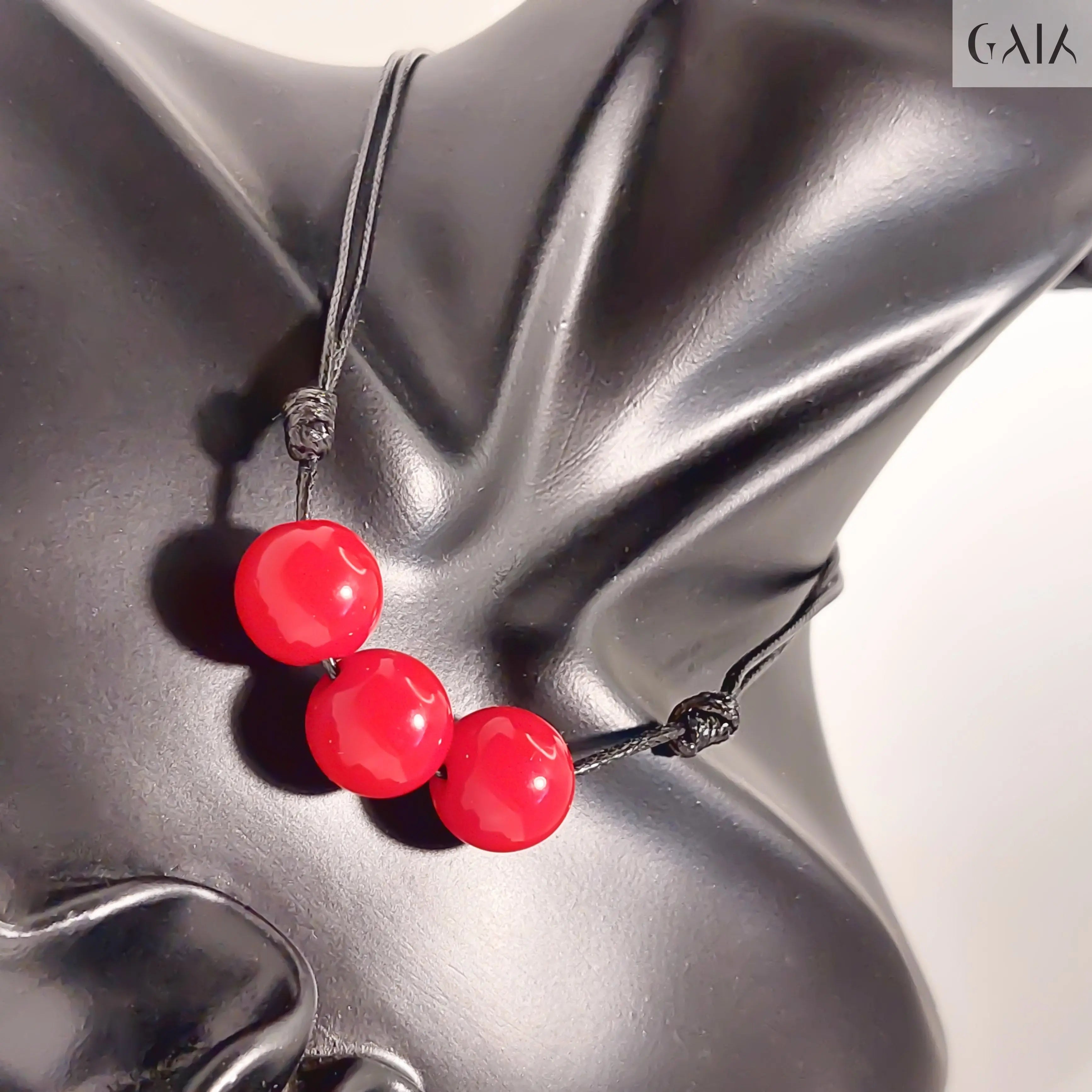 Necklace with red beads on a gray mannequin bust