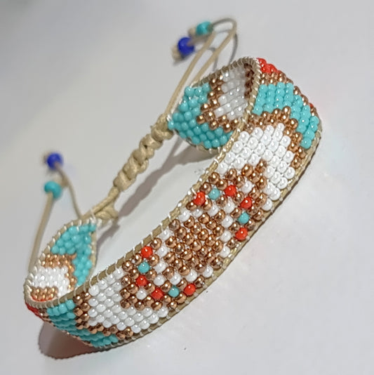 Beaded bracelet with turquoise, gold, and red pattern on a white background