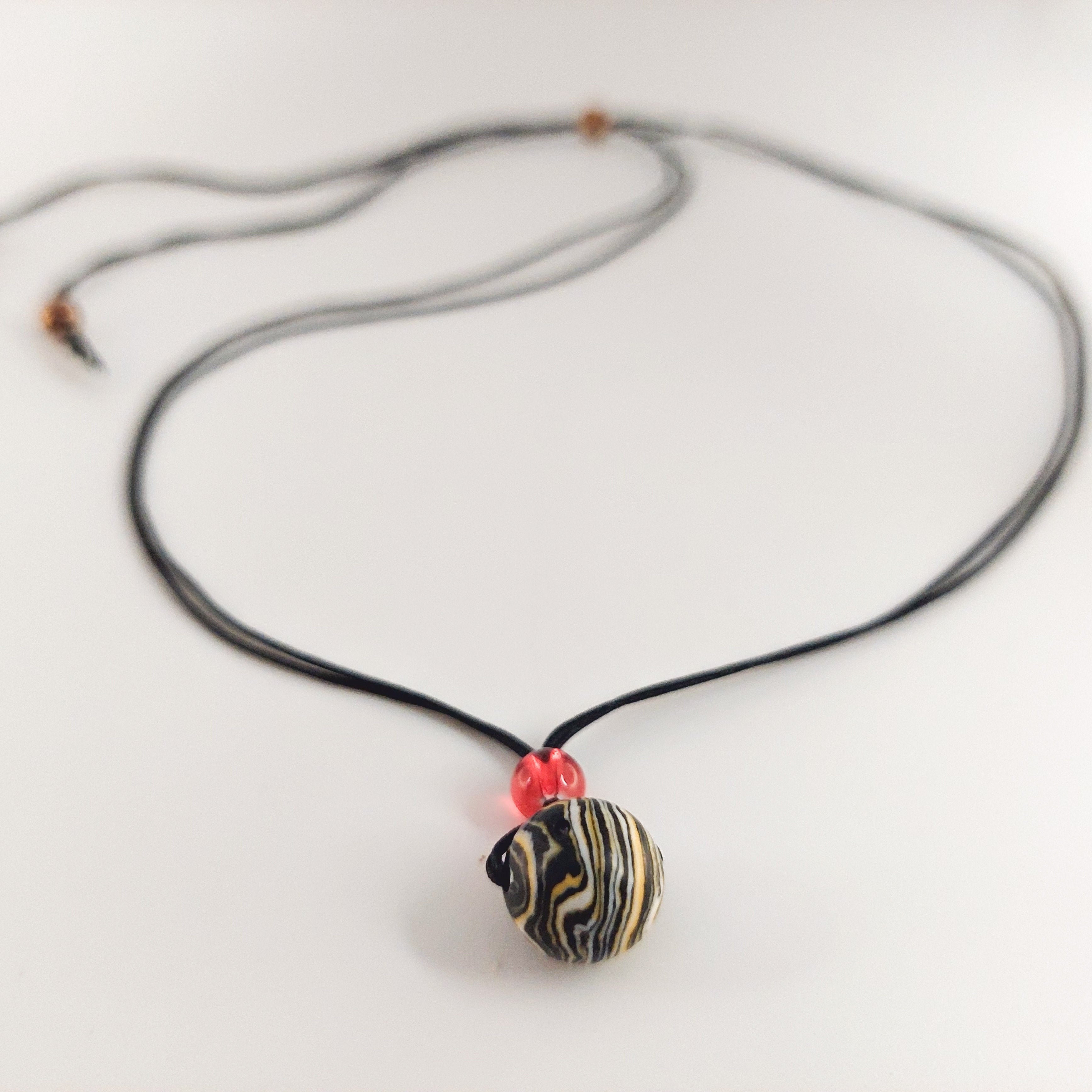 Necklace with a black and gold pendant on a white background