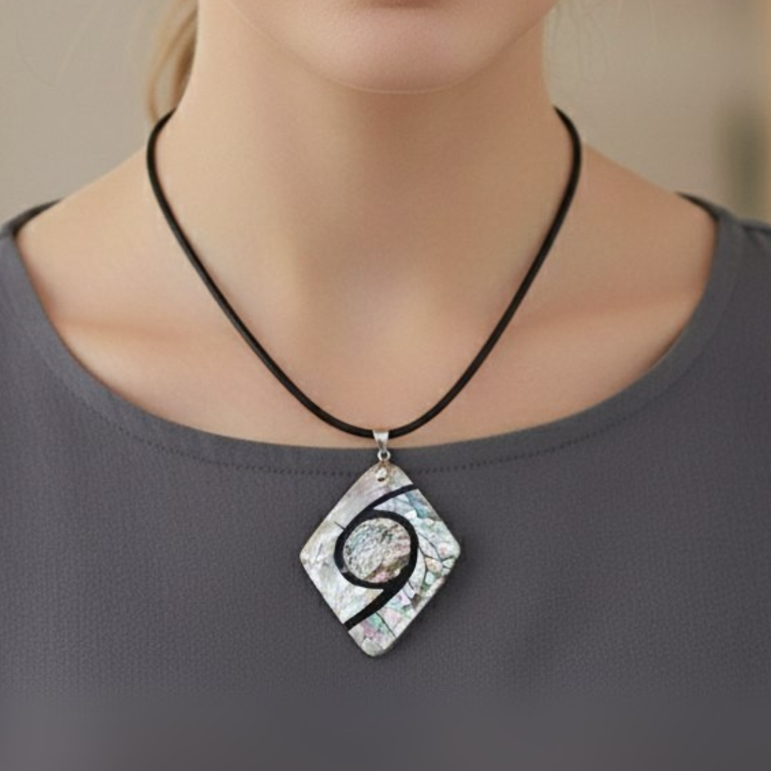 Necklace with a diamond-shaped pendant worn by a person against a neutral background