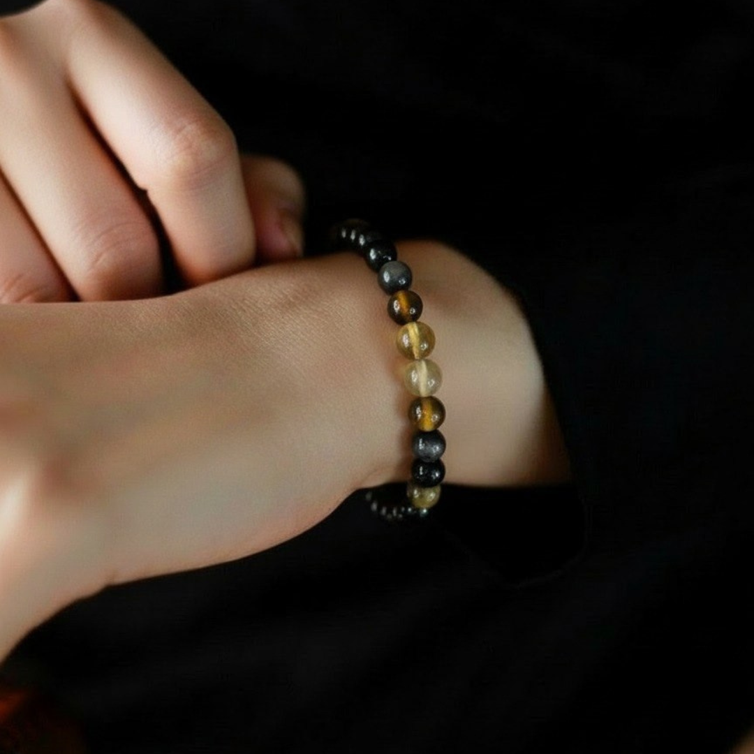 Close-up of a wrist wearing a beaded bracelet against a dark background