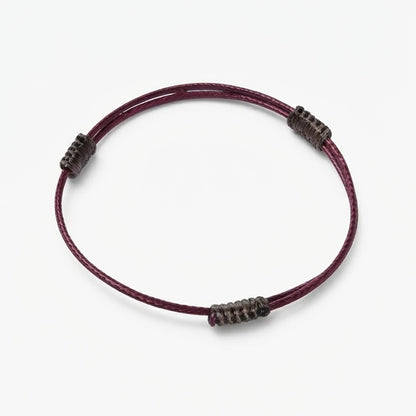Minimal burgundy cord bracelet with dark wrapped knot details.
