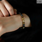Close-up of a wrist wearing a beaded bracelet against a dark background