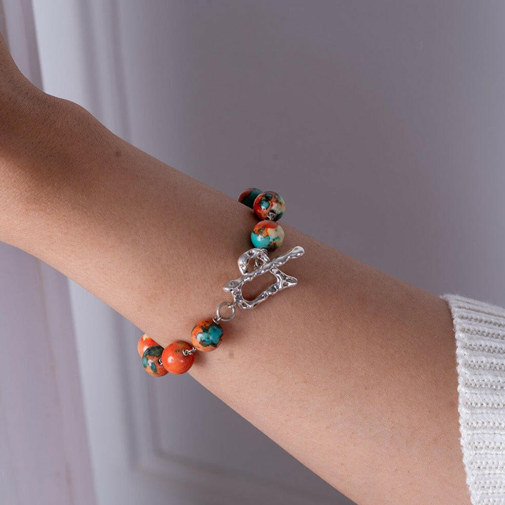 Tap into your intuitive side with this orange, blue rainbow stone bracelet with a sterling silver heart-shaped toggle clasp.