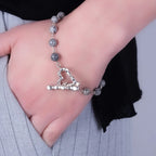 Close-up of a Grey Labradorite Bracelet with silver heart clasp worn on wrist, showcasing natural shimmer and elegant design