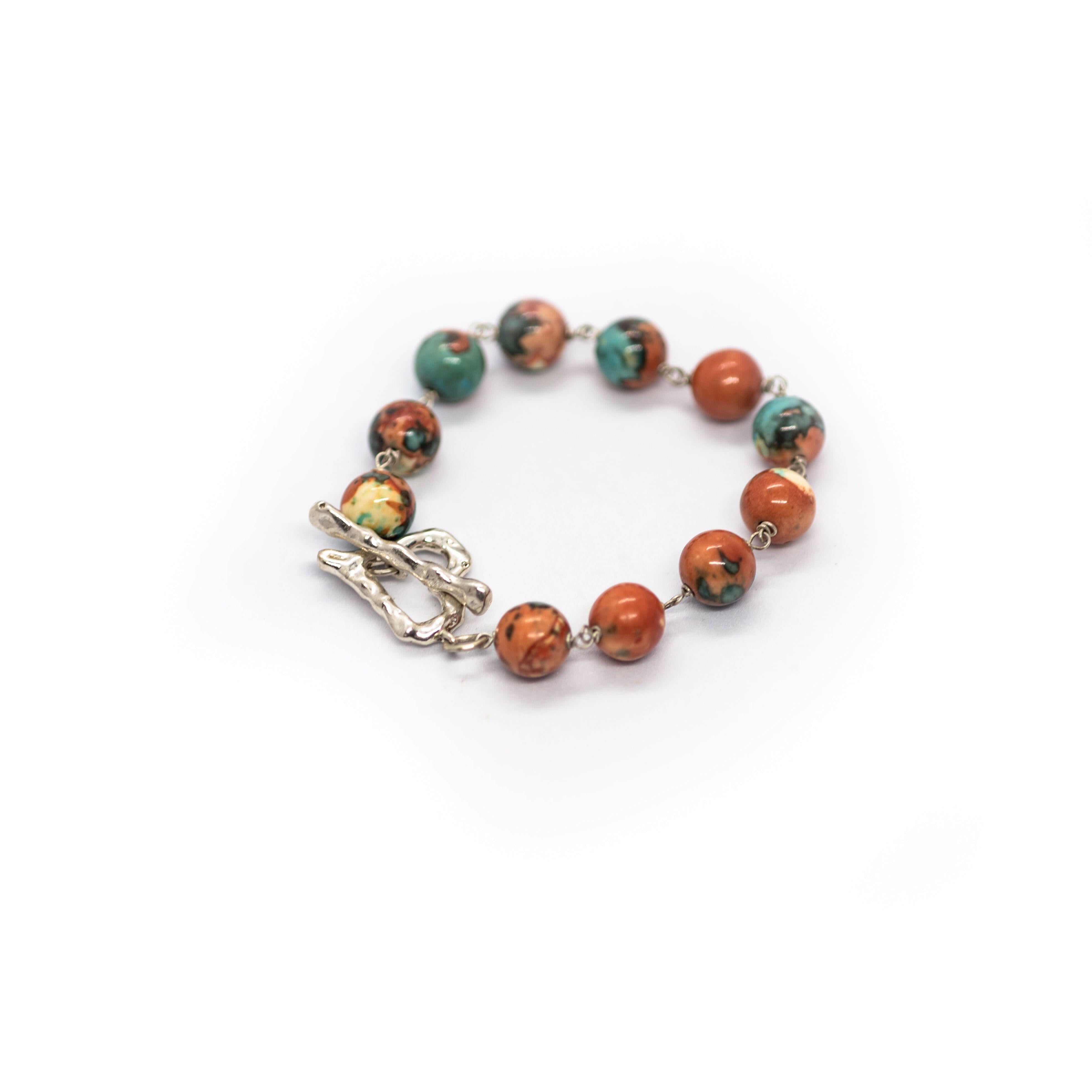 Tap into your intuitive side with this orange, blue rainbow stone bracelet with a sterling silver heart-shaped toggle clasp.