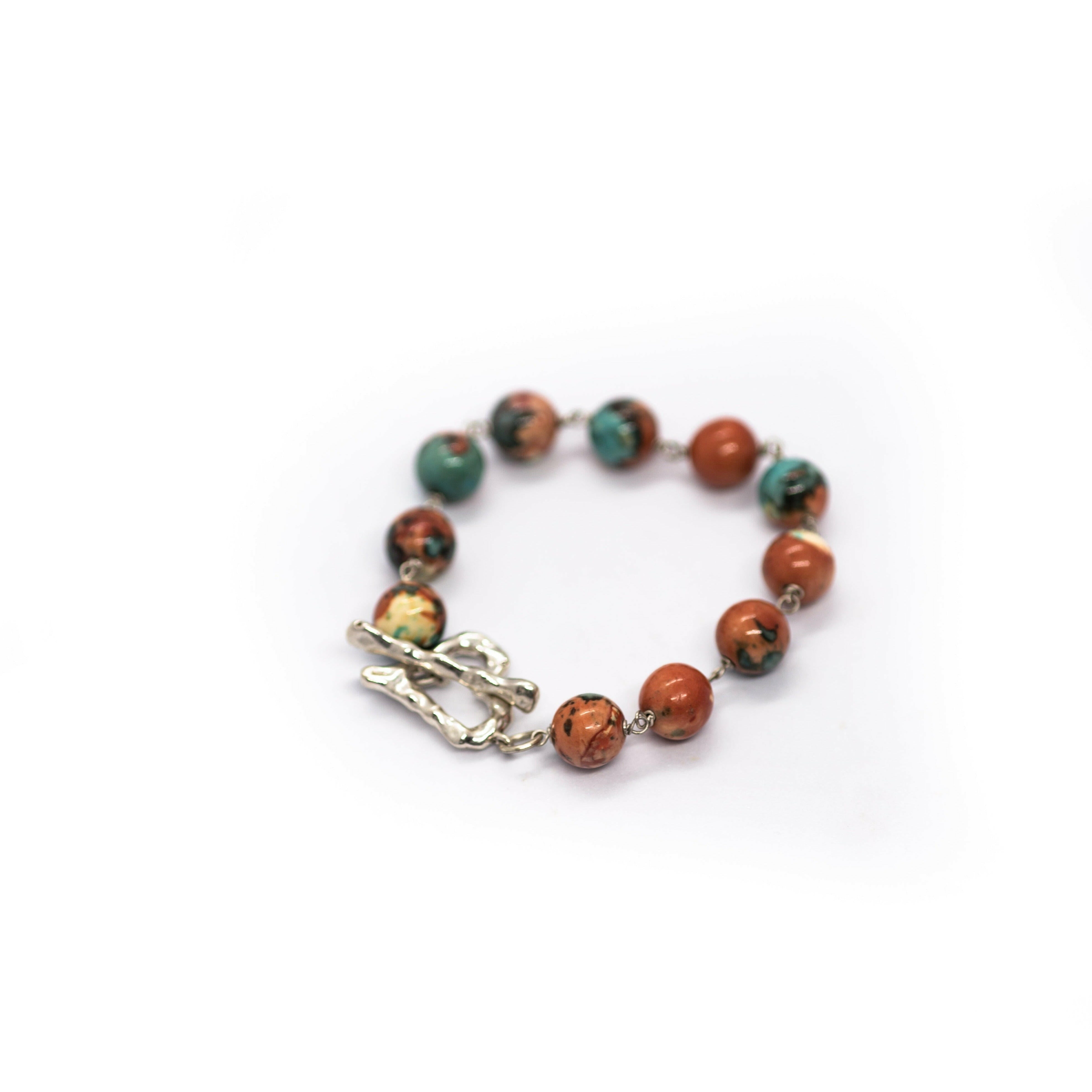 Tap into your intuitive side with this orange, blue rainbow stone bracelet with a sterling silver heart-shaped toggle clasp.