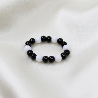 Black and white beaded bracelet on a white fabric background