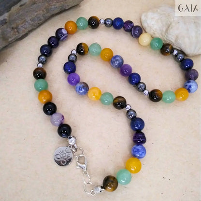 Multicolored beaded necklace with a silver charm on a beige surface