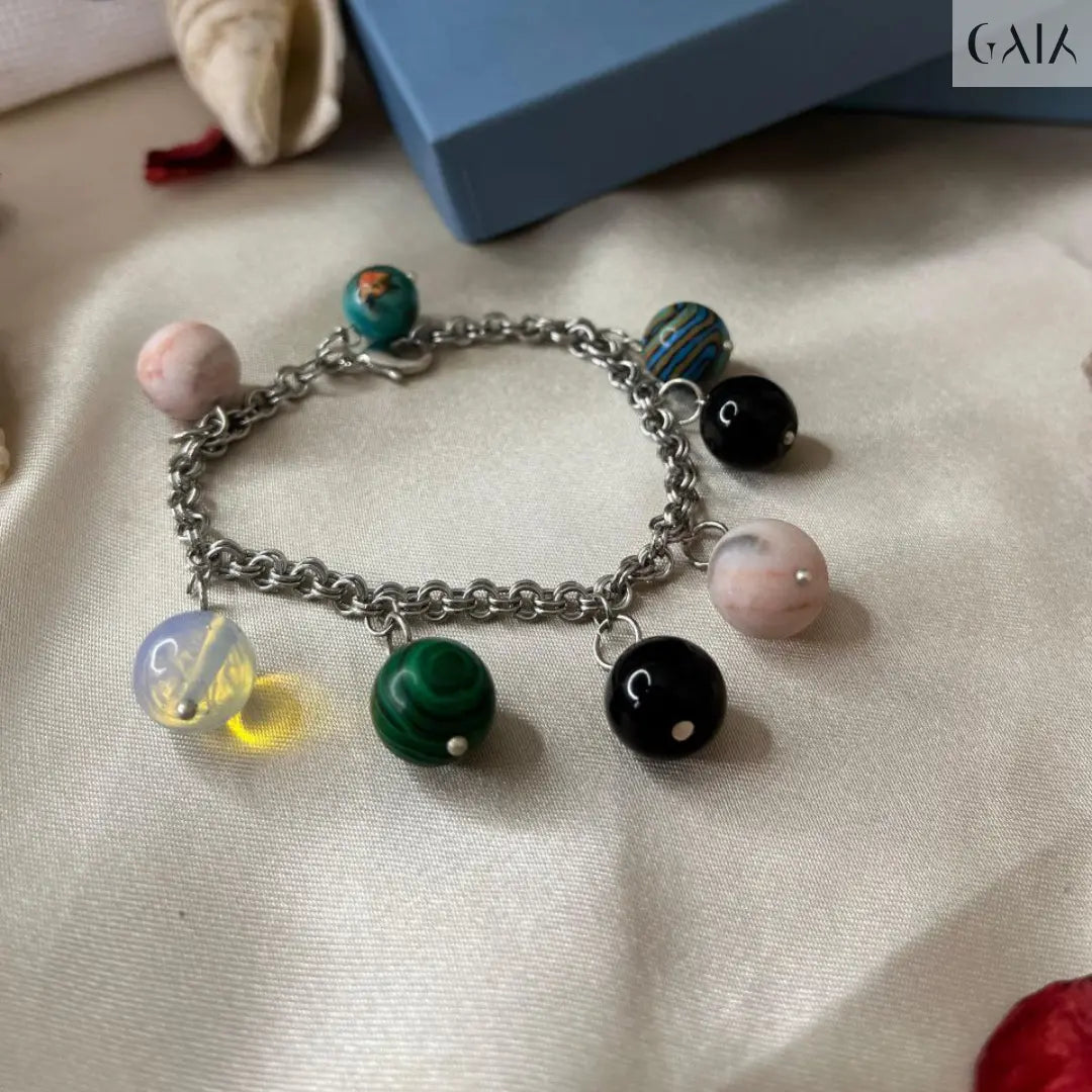 Bracelet with colorful charms on a textured surface with a blue box in the background