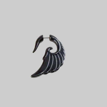 Black wing-shaped earring on a white background