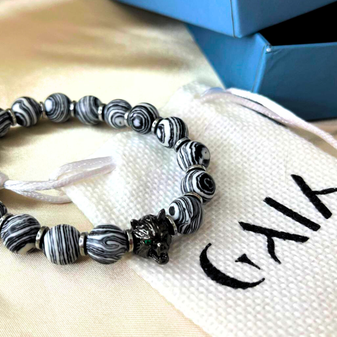 Black and white beaded bracelet on a white drawstring bag with 'Galia' branding.