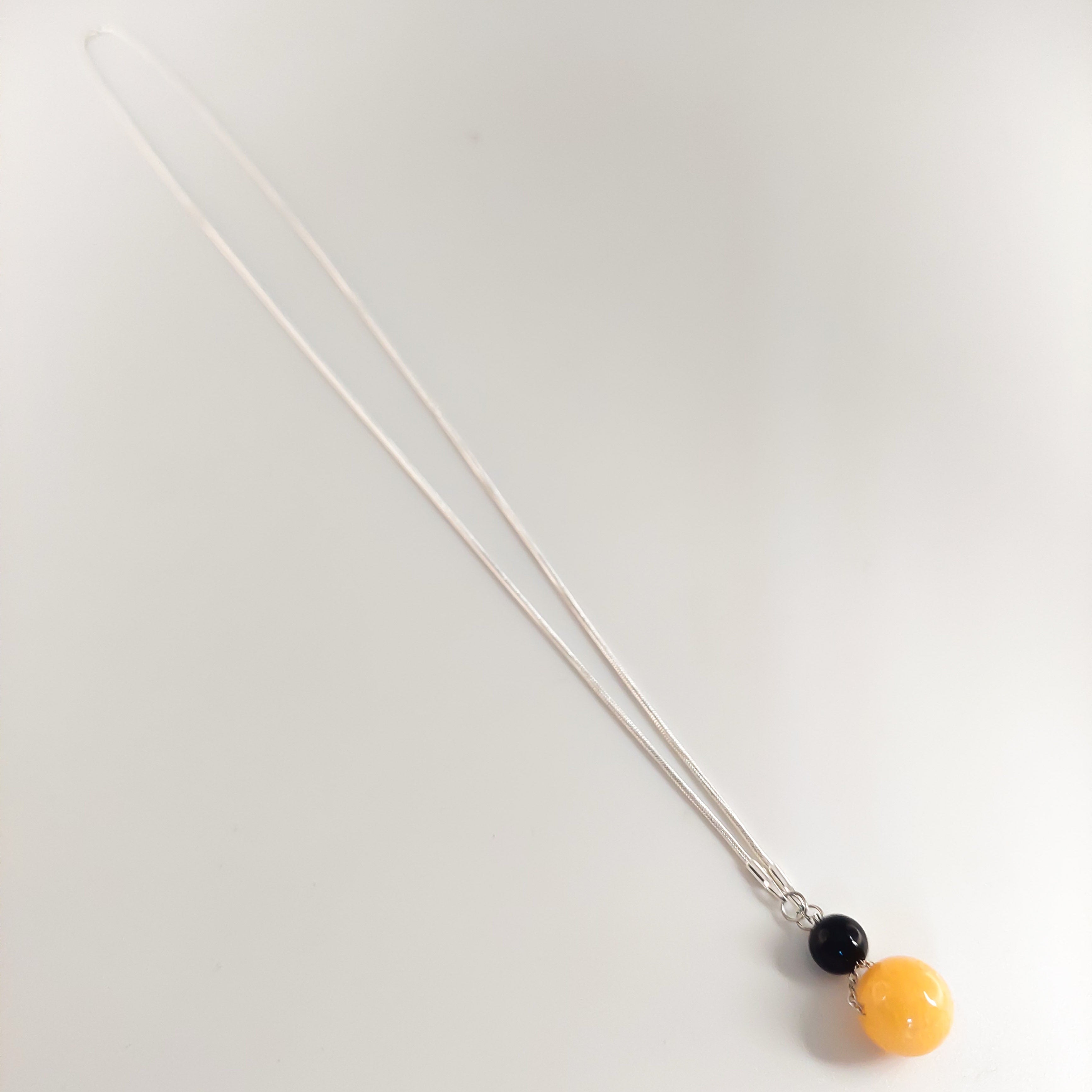Necklace with three beads on a white background

