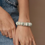 Person wearing a bracelet on a neutral background