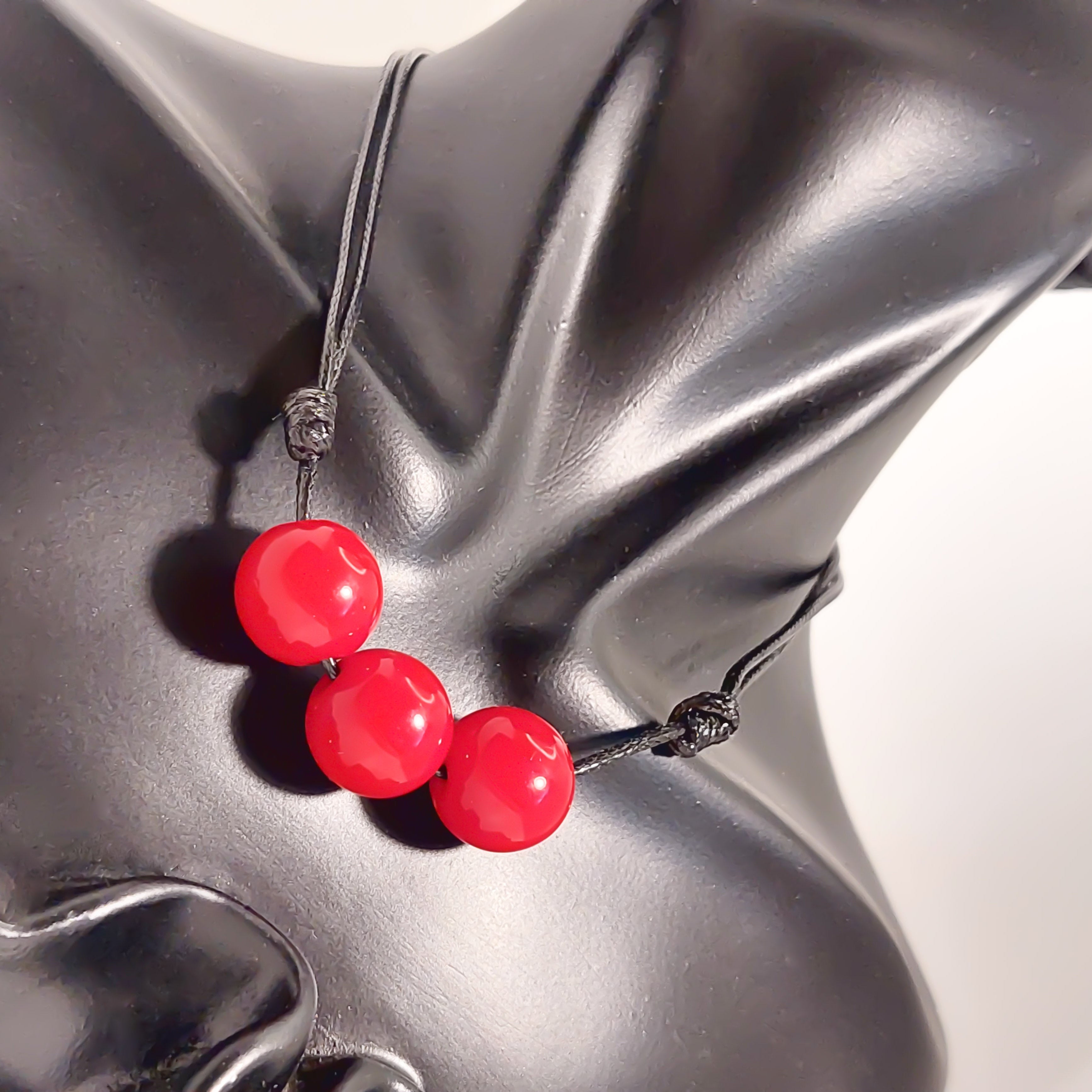 Necklace with red beads on a gray mannequin bust
