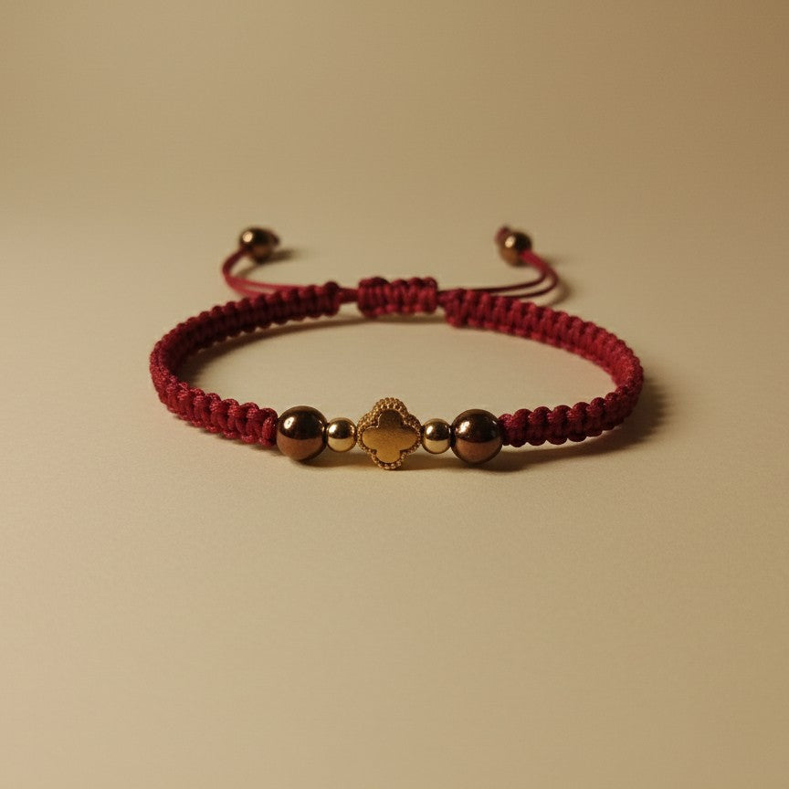 Red bracelet with gold beads on a beige background