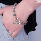 Close-up of a Grey Labradorite Bracelet with silver heart clasp worn on wrist, showcasing natural shimmer and elegant design
