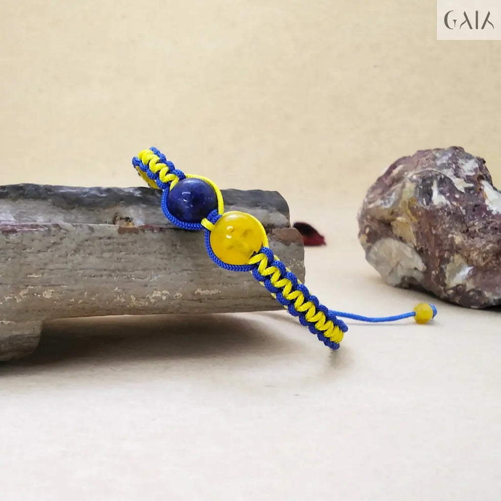Bracelet with blue and yellow cord on a stone surface