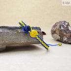 Bracelet with blue and yellow cord on a stone surface