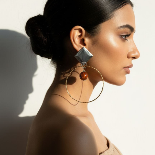 Woman wearing large hoop earrings with a neutral background