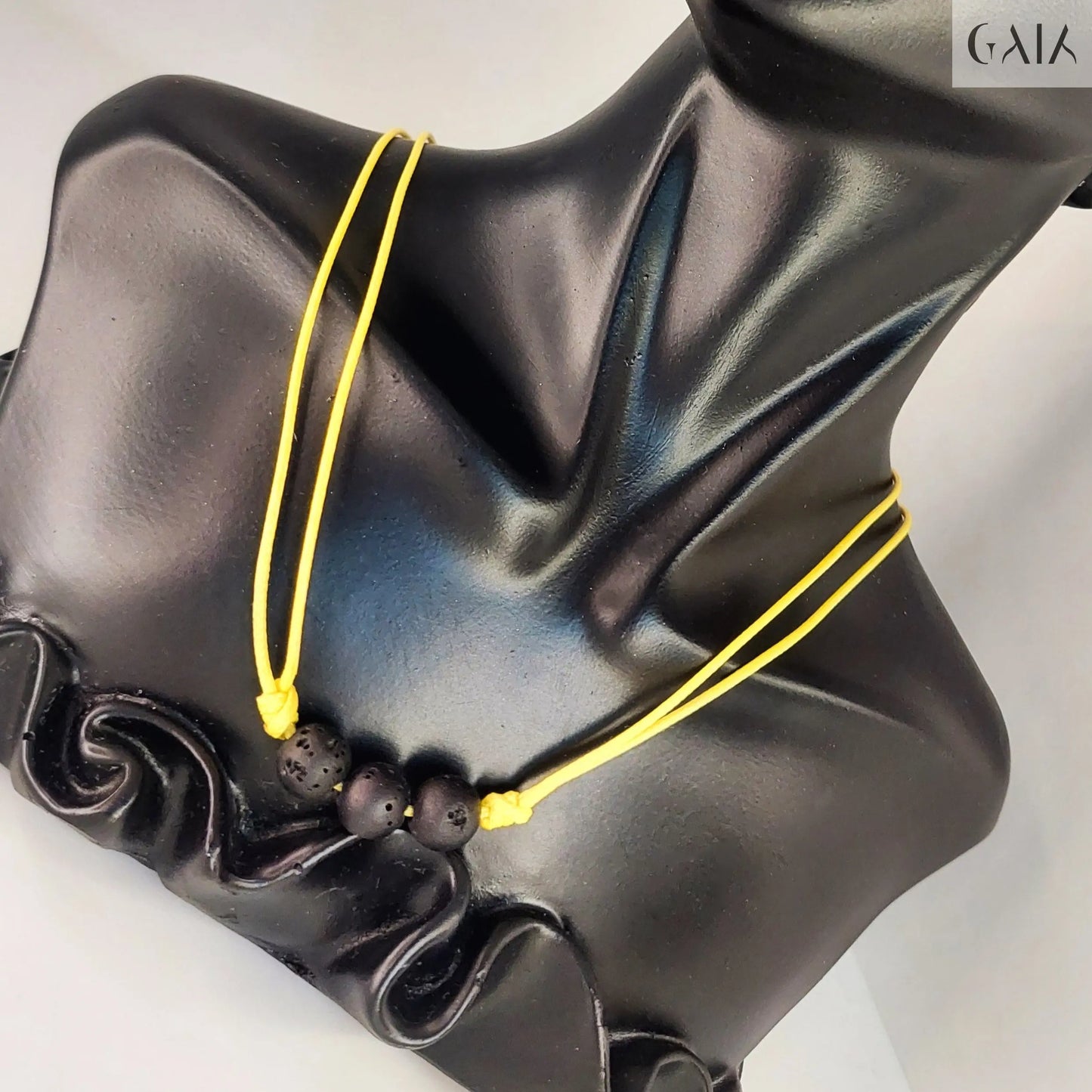 Black classical bust with yellow string on a white background