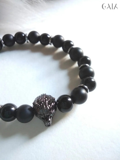 Black beaded bracelet with a lion head charm on a white background
