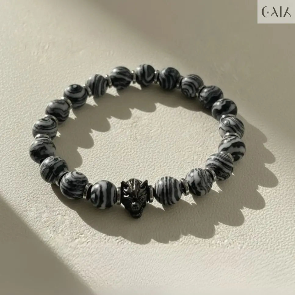 Black and white beaded bracelet on a beige background with 'GAIA' branding.