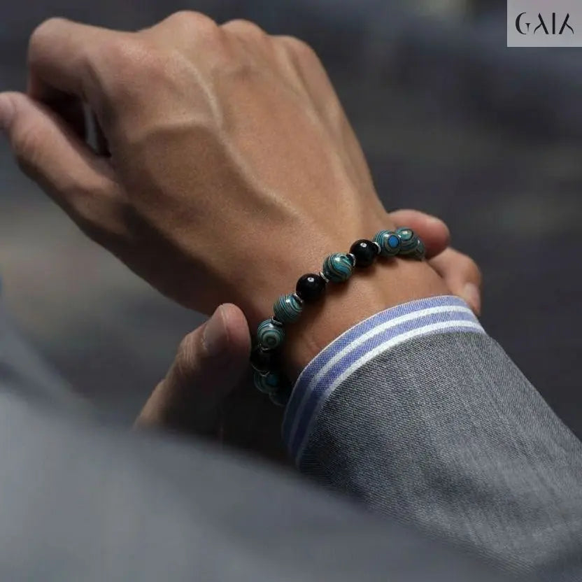 Hand wearing a beaded bracelet with a blurred background