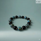 Beaded bracelet with black, blue, and silver beads on a light gray background