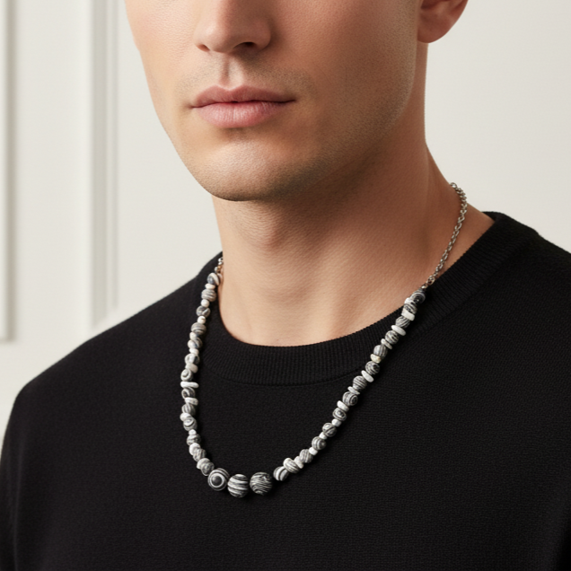 Man wearing a necklace with a neutral background