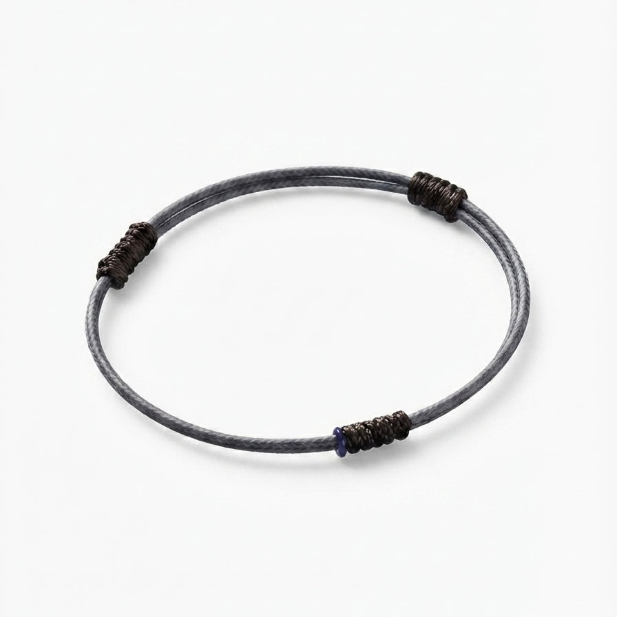 Minimal grey cord bracelet with dark wrapped knot details.