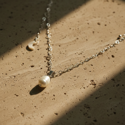 Pearl necklace on a textured beige surface