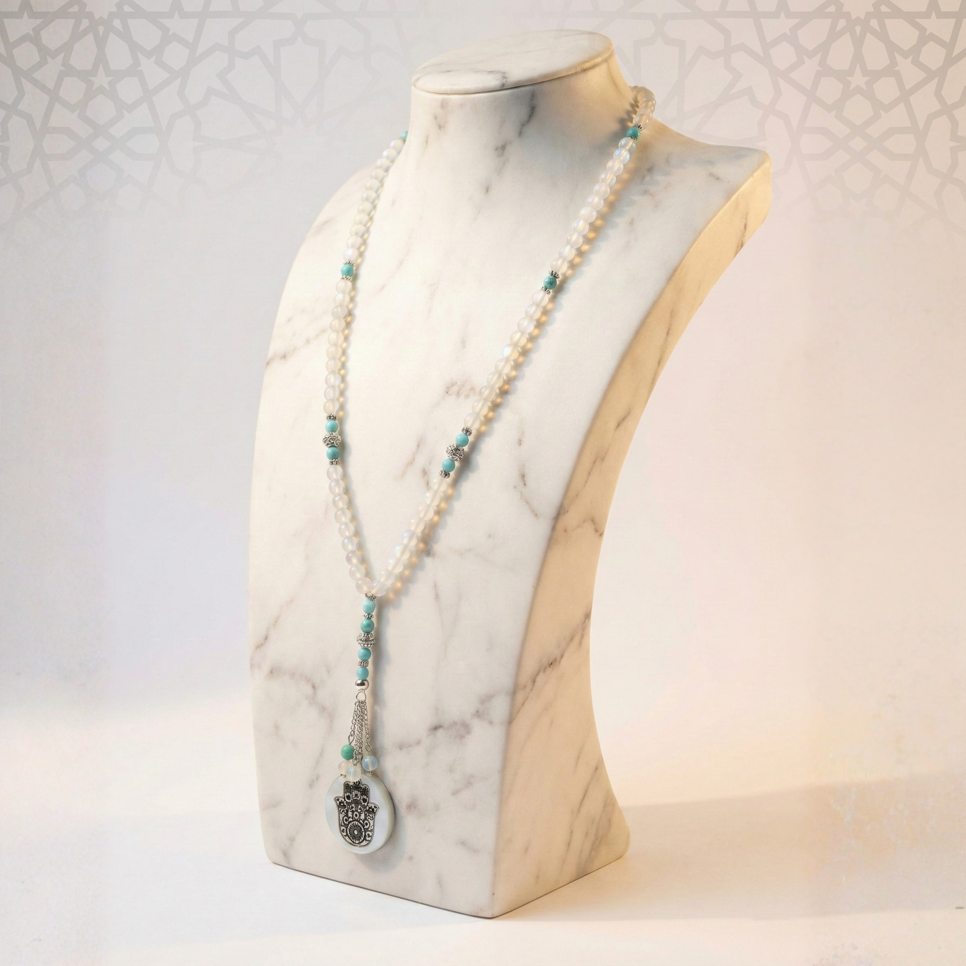 Pearl and turquoise beaded necklace on a marble mannequin bust.