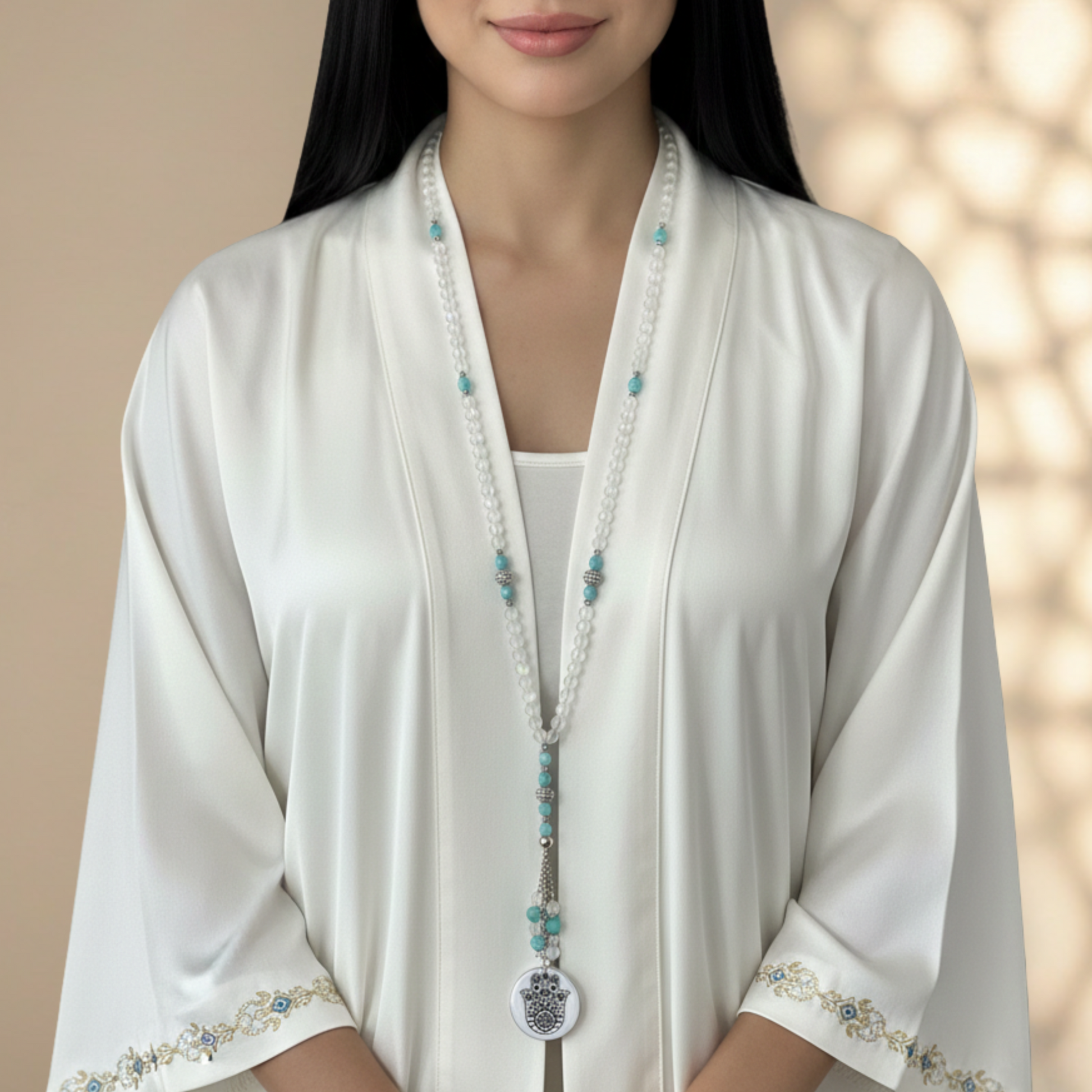 Woman wearing a white outfit with decorative elements against a neutral background