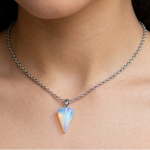 Woman wearing a necklace and pearl earrings against a neutral background