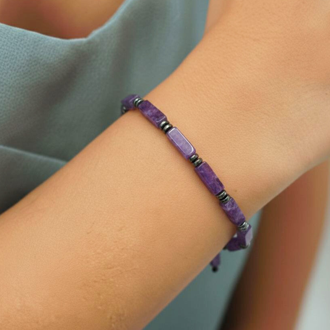 Purple beaded bracelet on a wrist with a neutral background
