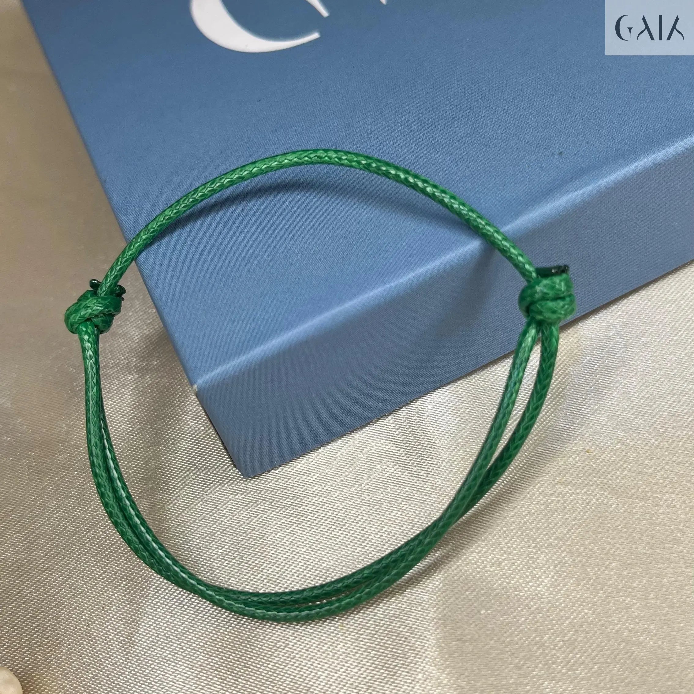 Green bracelet on a blue box with 'GAIA' branding.