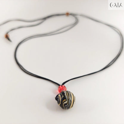 Necklace with a black and gold pendant on a white background

