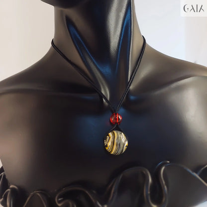 Black bust wearing a necklace with red and gold elements on a neutral background

