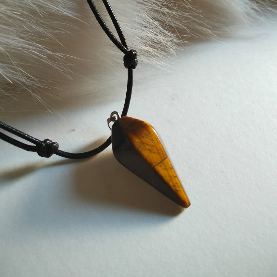 Wooden pendant on a black cord against a fur background