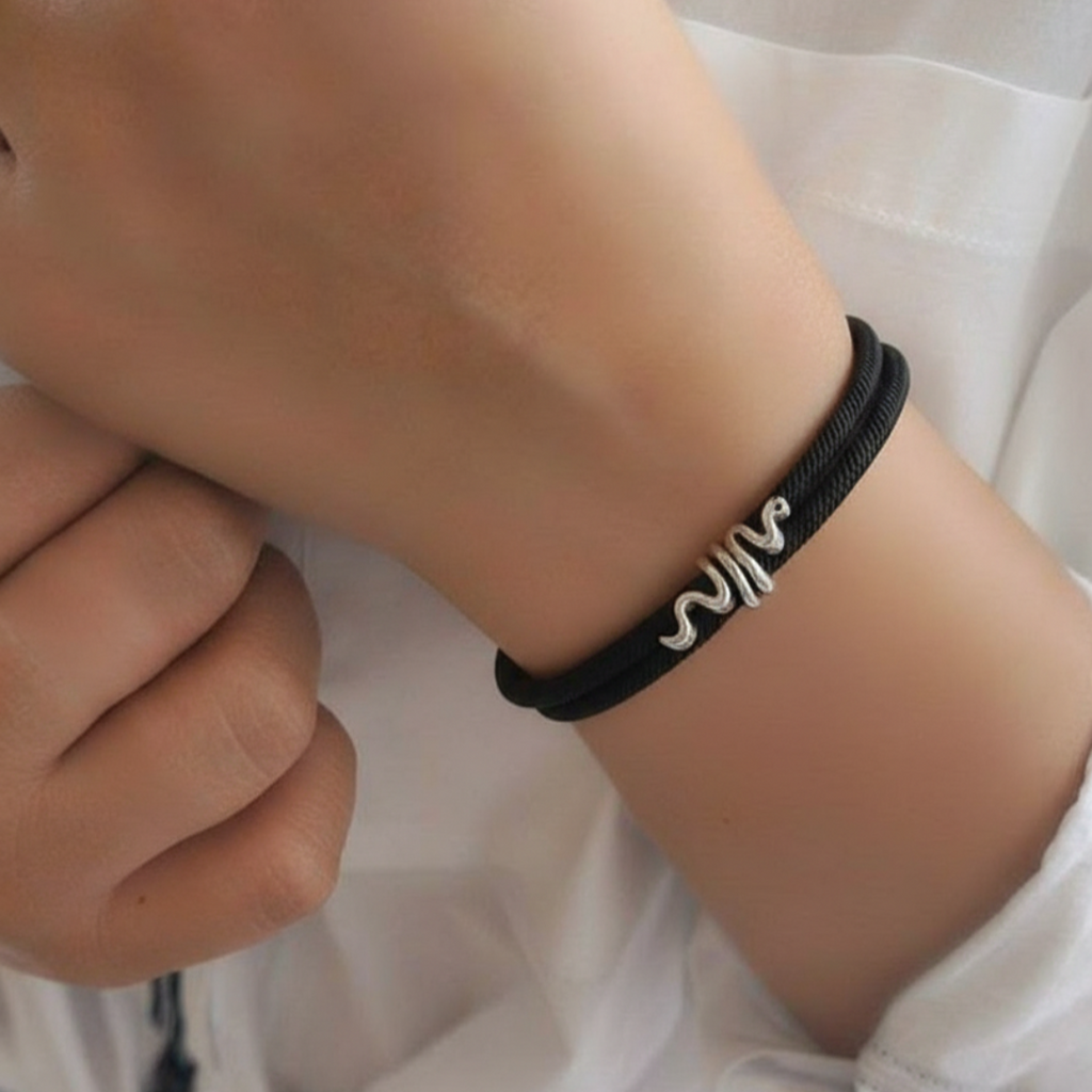 Person wearing a black bracelet with a white design on a white background