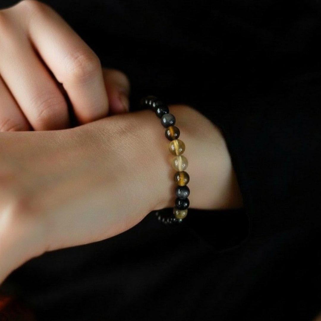 Close-up of a wrist wearing a beaded bracelet against a dark background